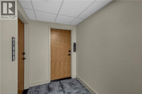 A hallway with a wooden door and a sign that says REALTOR.