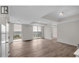 A spacious room with wooden floors and a sliding glass door leading to a balcony.