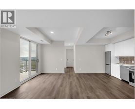 A spacious, well-lit kitchen and living room with hardwood floors and modern appliances.