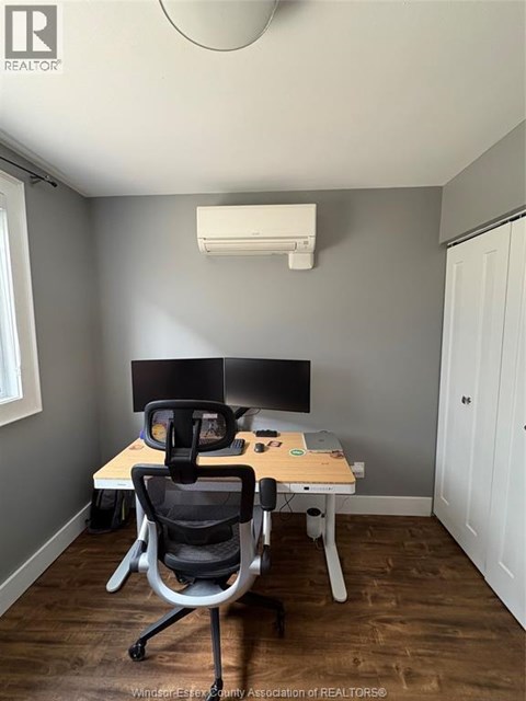 A room with a desk and a computer monitor.