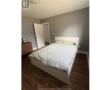 A bedroom with a bed, dresser, and nightstand.