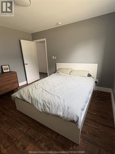 A bedroom with a bed, dresser, and nightstand.