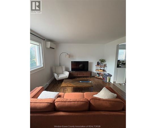 A living room with a brown couch and a wooden coffee table.