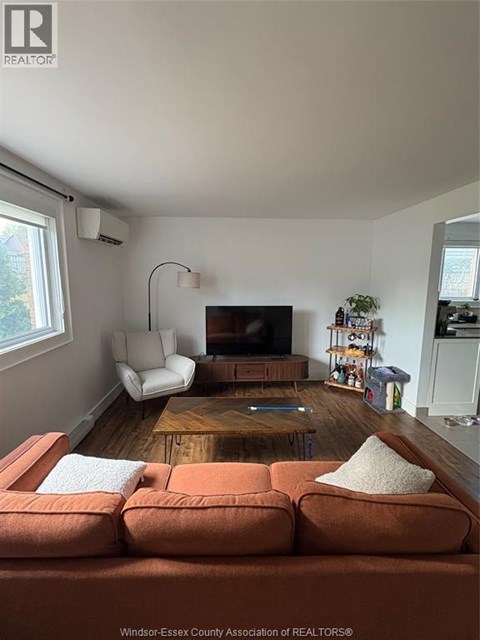 A living room with a brown couch and a wooden coffee table.