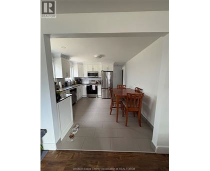 A kitchen with a table and chairs in the middle of the room.