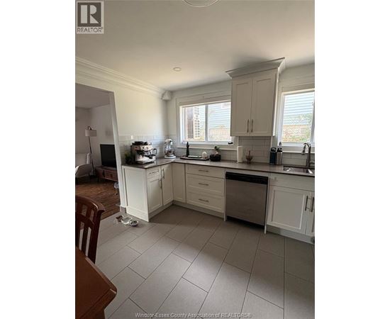 A kitchen with white cabinets and a wooden table.