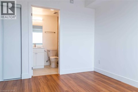 A bathroom with a toilet and sink is visible from a hallway.