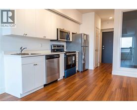 A modern kitchen with white cabinets and stainless steel appliances.