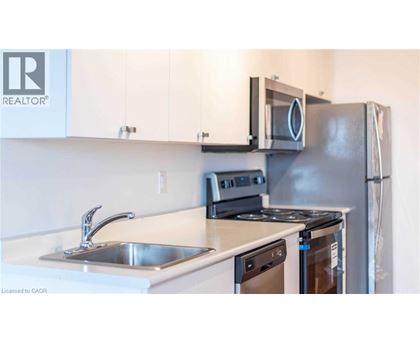 A kitchen with a stove, sink, and refrigerator.