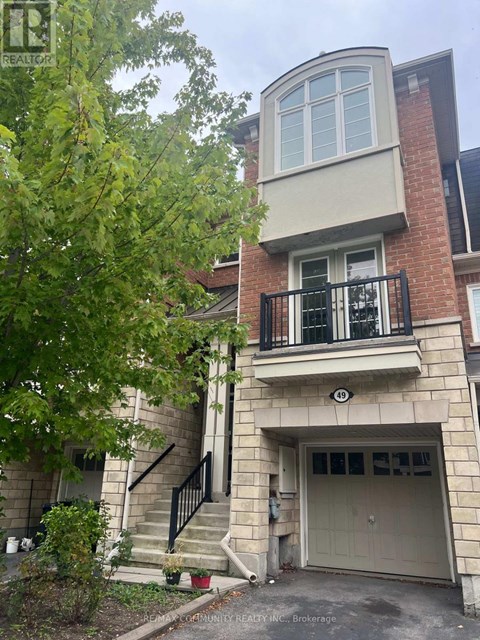 A brick building with a balcony and a garage door.