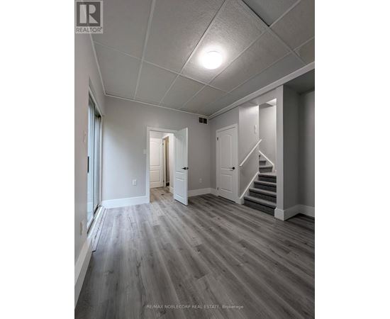 A spacious room with wooden floors and white walls.