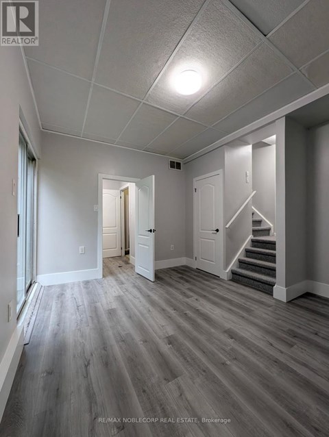 A spacious room with wooden floors and white walls.