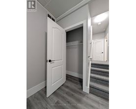 A white door is open to a hallway with a staircase.