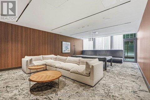 A living room with a large sectional sofa, a coffee table, and a rug.