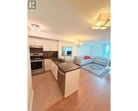 A kitchen with white cabinets and a black countertop.