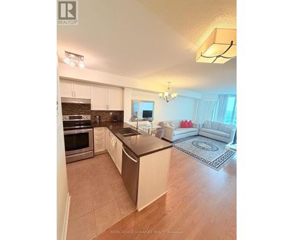 A kitchen with white cabinets and a black countertop.
