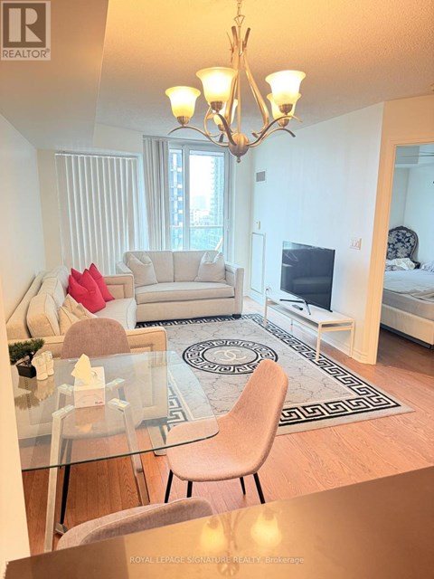 A well-lit, modern living room with a glass table and a white sofa.
