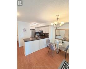 A kitchen with white cabinets and a black counter top.
