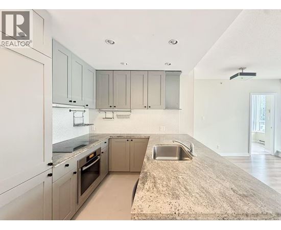 A kitchen with a sink and a refrigerator.