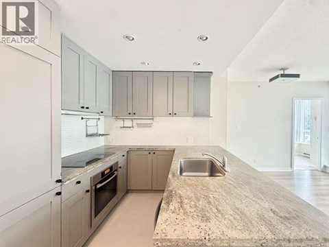 A kitchen with a sink and a refrigerator.