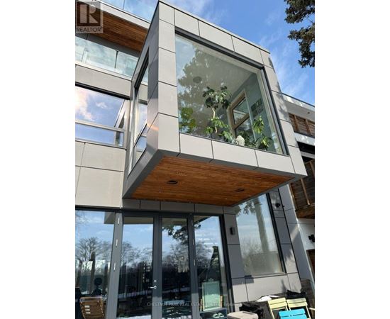 A modern building with a glass facade and a wooden roof.