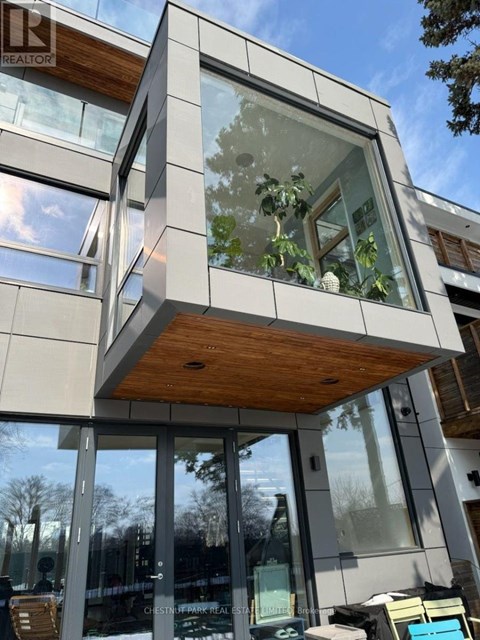 A modern building with a glass facade and a wooden roof.