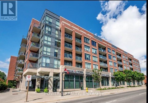 A multi-story building with a red brick facade and balconies.