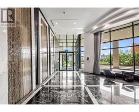 A hallway with a marble floor and a glass wall on one side.