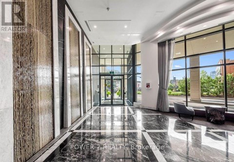A hallway with a marble floor and a glass wall on one side.