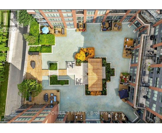An aerial view of a courtyard surrounded by buildings with a sign that reads "POWER 7 REALTY Brokerage".