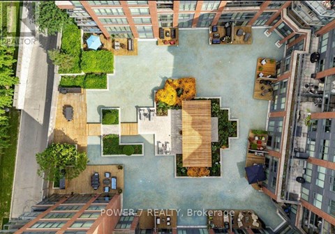 An aerial view of a courtyard surrounded by buildings with a sign that reads "POWER 7 REALTY Brokerage".