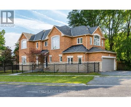 A large brick house with a black fence in front.