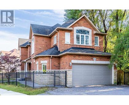 A brick house with a black fence and a garage door.