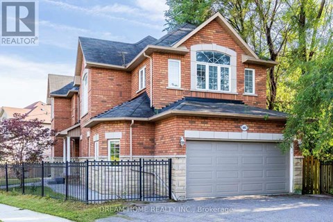 A brick house with a black fence and a garage door.