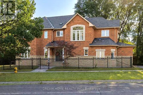 A brick house with a black fence in front.