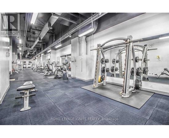 A gym with a variety of equipment including dumbbells and weight machines.