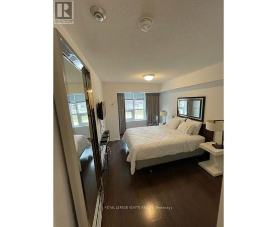 A bedroom with a large bed and a mirror on the wall.