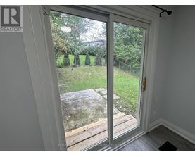 A sliding glass door with a view of a backyard.