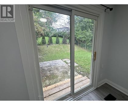 A sliding glass door with a view of a backyard.