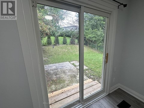 A sliding glass door with a view of a backyard.