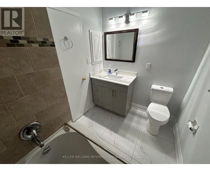 A bathroom with a toilet, sink, and shower.