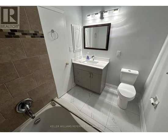 A bathroom with a toilet, sink, and shower.