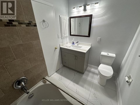 A bathroom with a toilet, sink, and shower.