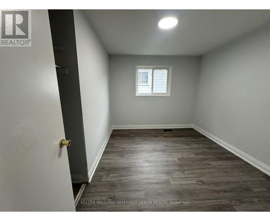A room with a wooden floor and a window with white blinds.