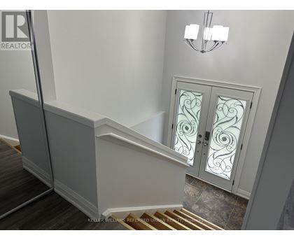 A staircase with a glass door and a chandelier.