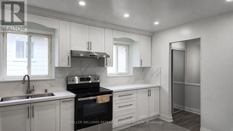 A kitchen with a stove top oven and a sink.