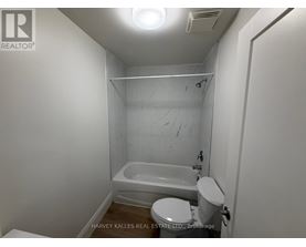 A small white bathroom with a toilet, sink and bathtub.