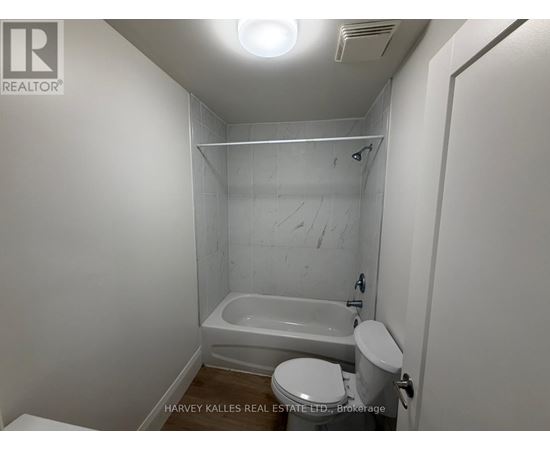 A small white bathroom with a toilet, sink and bathtub.