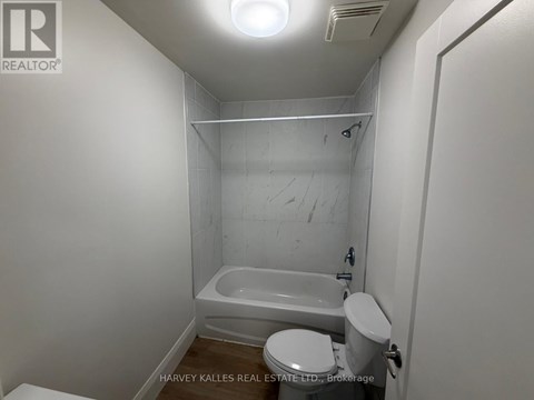 A small white bathroom with a toilet, sink and bathtub.