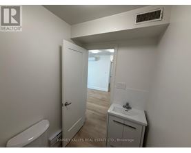 A small bathroom with a toilet, sink and a door.